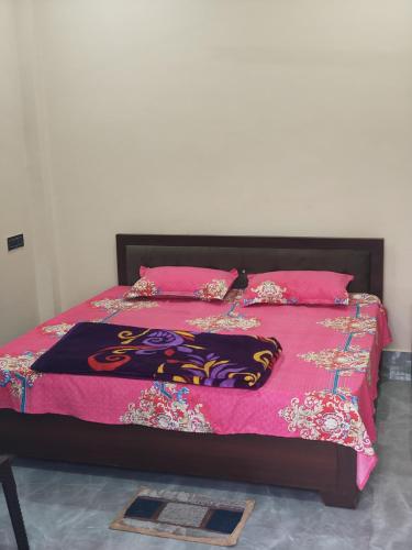 a bed with a pink blanket and pillows on it at Prem Saroj homestay in Ayodhya