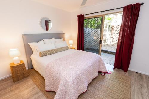 a bedroom with a bed and a sliding glass door at Jara - U19 Pandanus Palms Resort in Point Lookout