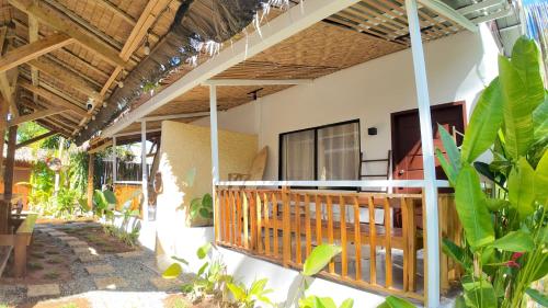 a house with a balcony with a wooden railing at Bom Dia Siargao Villas in General Luna