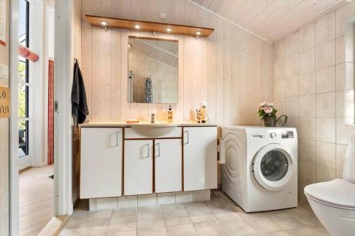 a bathroom with a washing machine and a sink at LF12022-Spottrup-Skovmarken-2 in Vadum