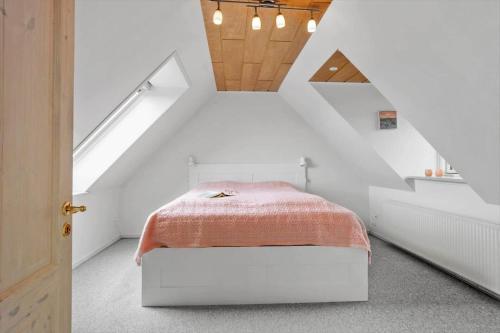 a white bedroom with a bed in a attic at FY410-Faaborg-Mosetoften-10-B in Diernæs