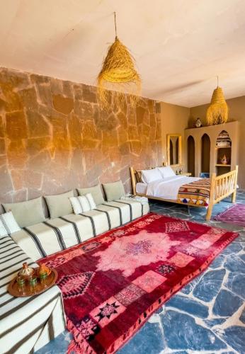 a bedroom with a couch and a bed in a room at Ouberge 'loassis house in Douar Azrou Melloul