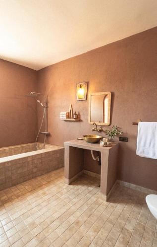 a bathroom with a sink and a shower and a tub at Ouberge 'loassis house in Douar Azrou Melloul