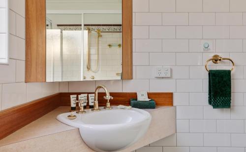 a bathroom with a white sink and a mirror at Robyn's Nest Lakeside Resort in Merimbula