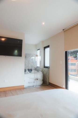 a white bedroom with a tub and a sink at Saya Hotel & Suites in Cuenca