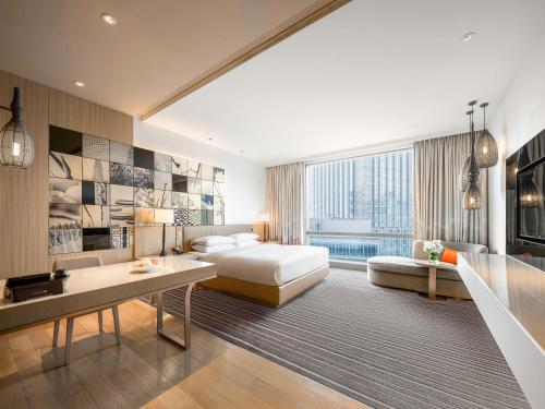 a hotel room with a bed and a desk and a couch at Hyatt Regency Suzhou in Suzhou
