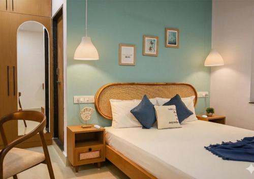 a bedroom with a bed with blue walls and a chair at Nivara Stays Lingampalli, A Boutique Hotel Brand in Hyderabad