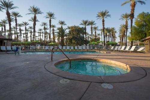 a small pool with palm trees in a resort at Palm Springs Camping Resort Cottage 1 in Palm Desert