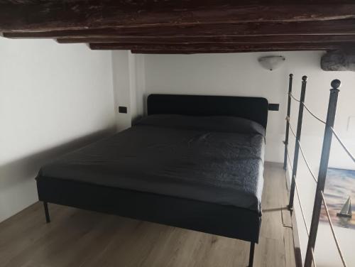 a black bed in a room with a wooden floor at Casa Maria - next Milano,Como, Varese in Caronno Pertusella