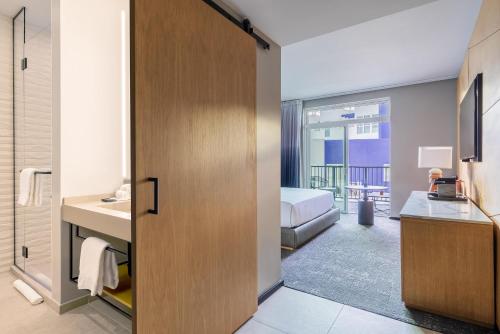 a room with a bathroom with a bed and a sink at The Shay, a Destination by Hyatt in Los Angeles