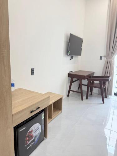 a living room with a tv and a table at Green Hotel in Khánh Dương