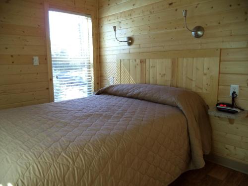 a bedroom with a bed in a wooden room at Palm Springs Camping Resort Cabin 3 in Palm Desert