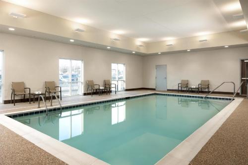 a large swimming pool with chairs and tables at Hyatt Select St Louis Airport in Saint Louis