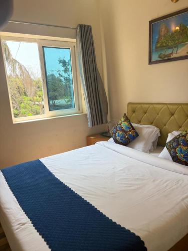 a bedroom with a large bed with a window at Serenity Beach House in Pondicherry