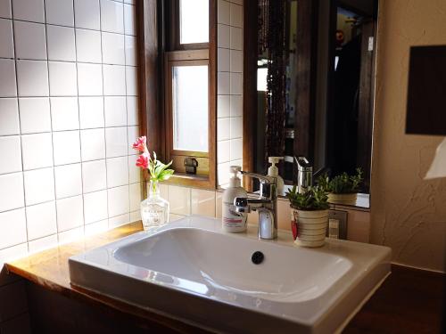 a white sink in a bathroom with a mirror at ゲストハウス豆まめ - Guesthouse Mamemame in Matsumoto