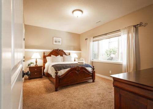 a bedroom with a large bed and a window at Opulent Oasis in Lethbridge