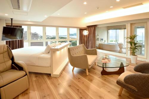 a bedroom with a large bed and a living room at BREATH HOTEL in Fujisawa