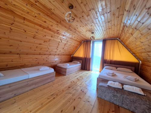 a room with two beds in a wooden cabin at Close to the sky in Agara