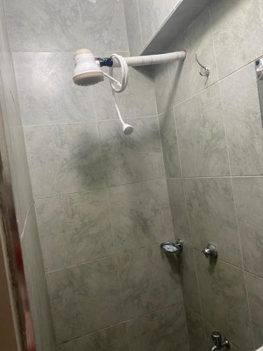 a shower with a shower head in a bathroom at Tripstar villa studio at Tsavo sunset Kiambu Road Thindigua in Kiambu