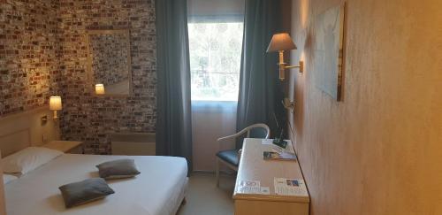 a hotel room with a bed and a window at Logis L'Auberge Bourbonnaise - Vichy sud in Saint-Yorre