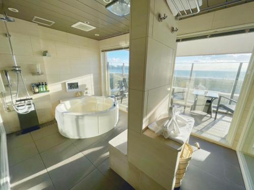 a bathroom with a large tub and a large window at BREATH HOTEL in Fujisawa