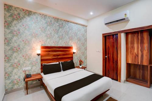 a bedroom with a bed and a wall with flowers at Super OYO Hotel O Khargapur Ring Road Formerly Shimla Grand in Lucknow