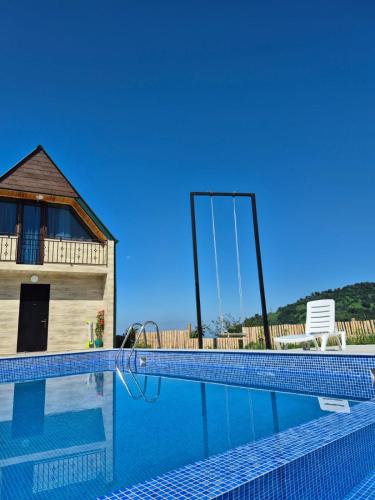 a swimming pool with a mirror in front of a house at Close to the sky in Agara