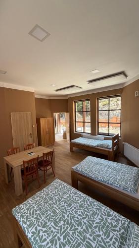 a room with two beds and a table and chairs at Penzion Florian in Moldava
