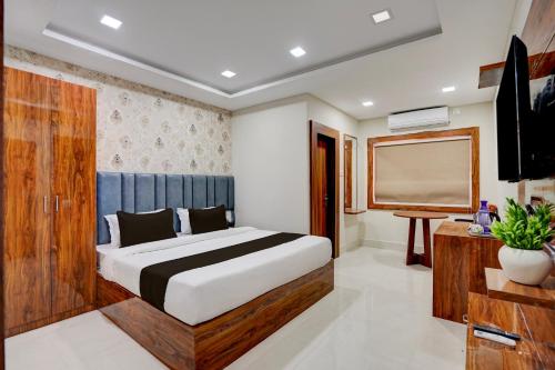 a bedroom with a bed and a flat screen tv at Super Collection O AIIMS Bhubaneshwar in Khandagiri