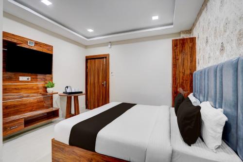 a bedroom with a large bed and a television at Super Collection O AIIMS Bhubaneshwar in Khandagiri