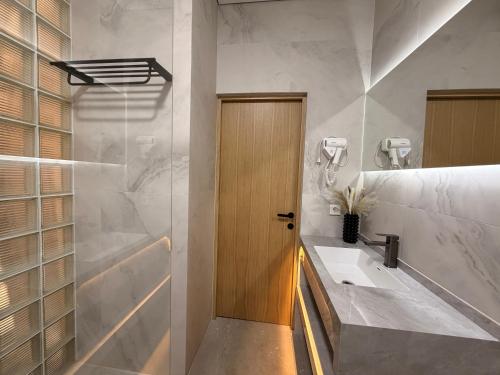 a bathroom with a sink and a wooden door at Keremet Hotel in Almaty