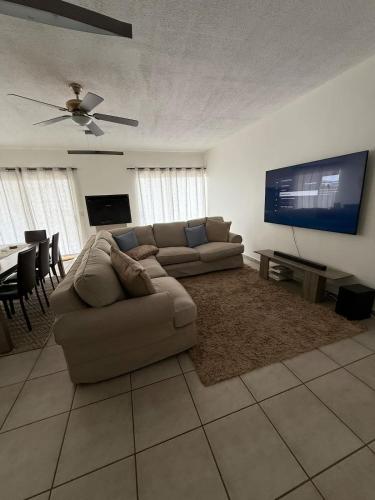 a living room with a couch and a flat screen tv at Tide's End in Langstrand
