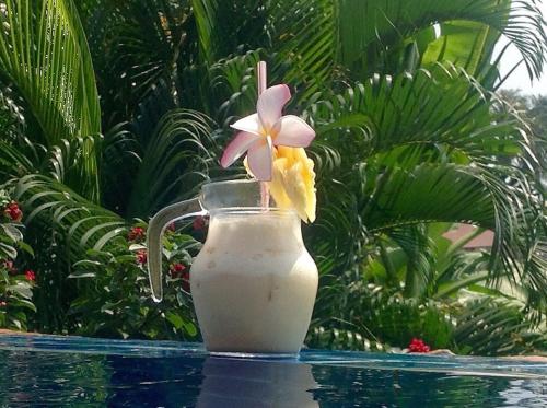 a jug of milk with a flower in it at Pink House Guest House Lamai - Pool & Sea View in Lamai