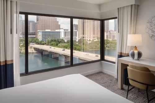 a bedroom with a bed and a desk and a large window at Hyatt Regency Austin in Austin