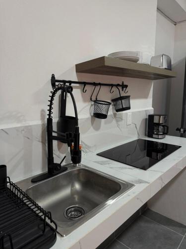 a kitchen counter with a sink and a kitchenilit at Freya Studio I Romantic Zone in Puerto Vallarta