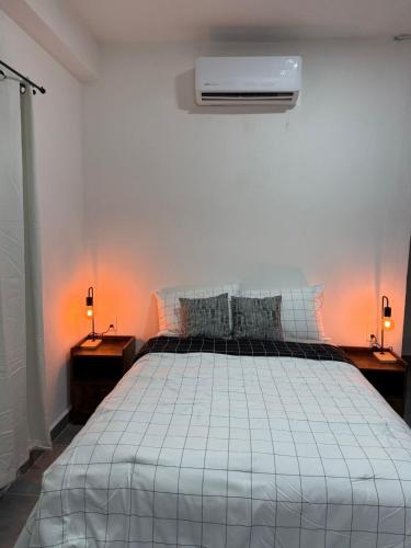 a bedroom with a bed with two lamps and a air conditioner at Freya Studio I Romantic Zone in Puerto Vallarta