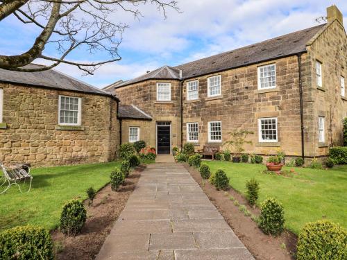 an old stone house with a pathway in front of it at Treetops, Alnwick in Alnwick