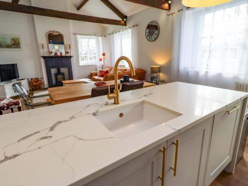 a kitchen with a sink and a living room at Treetops, Alnwick in Alnwick