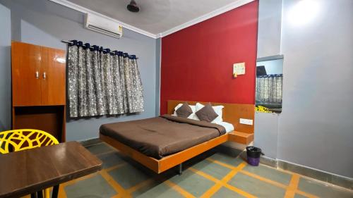 a bedroom with a bed with a red wall at Redwing Peaceful Studio in Navi Mumbai