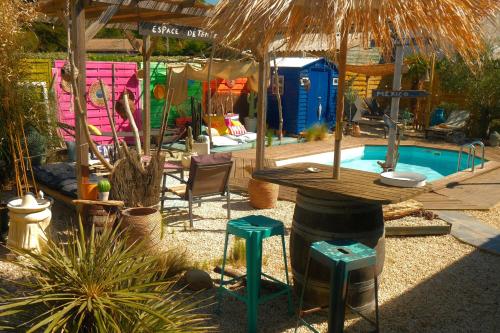 una piscina con tavolo e sgabelli in un cortile di La Norélie a Saint-Sulpice-de-Royan
