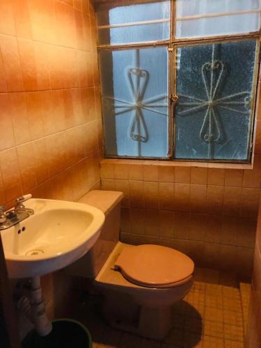 a bathroom with a sink and a toilet and a window at Casa Jardín Santiago in Texcoco de Mora