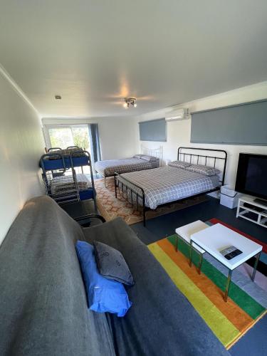 a living room with two beds and a couch at Saturn Parade Shack in Venus Bay
