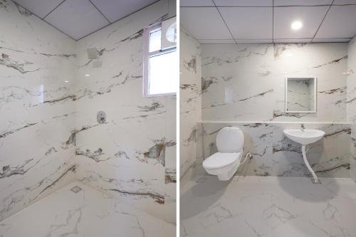 a white bathroom with a toilet and a sink at FabHotel Kences Inn in Chennai
