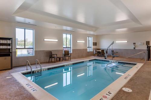 a swimming pool in a hotel with chairs and tables at Comfort Inn & Suites Clarkston Pine Knob Area in Clarkston