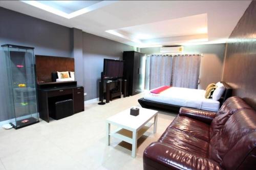 a living room with a couch and a bed at DelMar by Mery World Hospitality in Pattaya South