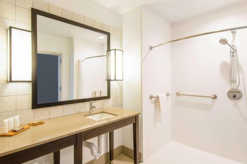 a bathroom with a sink and a shower with a mirror at Country Inn & Suites by Radisson, Flagstaff Downtown, AZ in Flagstaff
