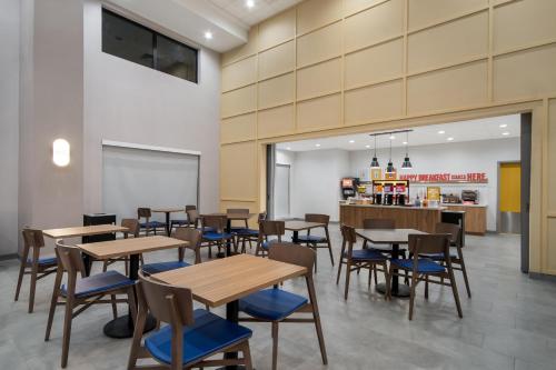 a restaurant with wooden tables and blue chairs at Hampton Inn & Suites By Hilton Irving Dfw Airport North in Irving