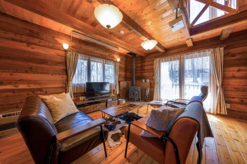 a living room with a couch and a tv in a log cabin at Log village FIKA / Nasu / Woodstove / Starry sky in Nasu