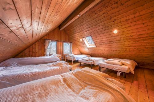 a bedroom with two beds in a wooden cabin at Log village FIKA / Nasu / Woodstove / Starry sky in Nasu