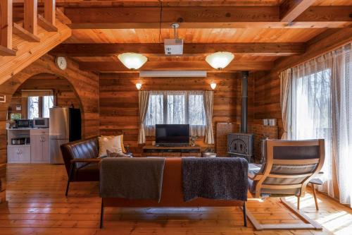a living room with a table and chairs and a television at Log village FIKA / Nasu / Woodstove / Starry sky in Nasu